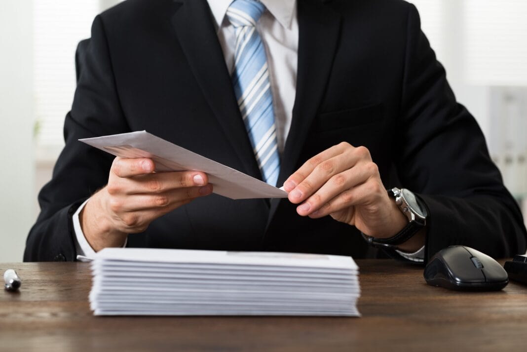 Businessman With Envelopes At Desk