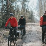 Jak zaplanować pierwszą wyprawę bikepackingową w weekend – poradnik krok po kroku Trzech rowerzystów z sakwami jedzie leśną ścieżką podczas wyprawy